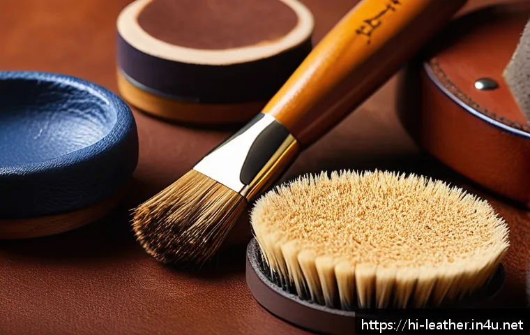 가죽공예 최적의 마감제 - A detailed close-up image of a leather artisan&rsquo;s workspace focusing on soft-bristle finishing brushe...